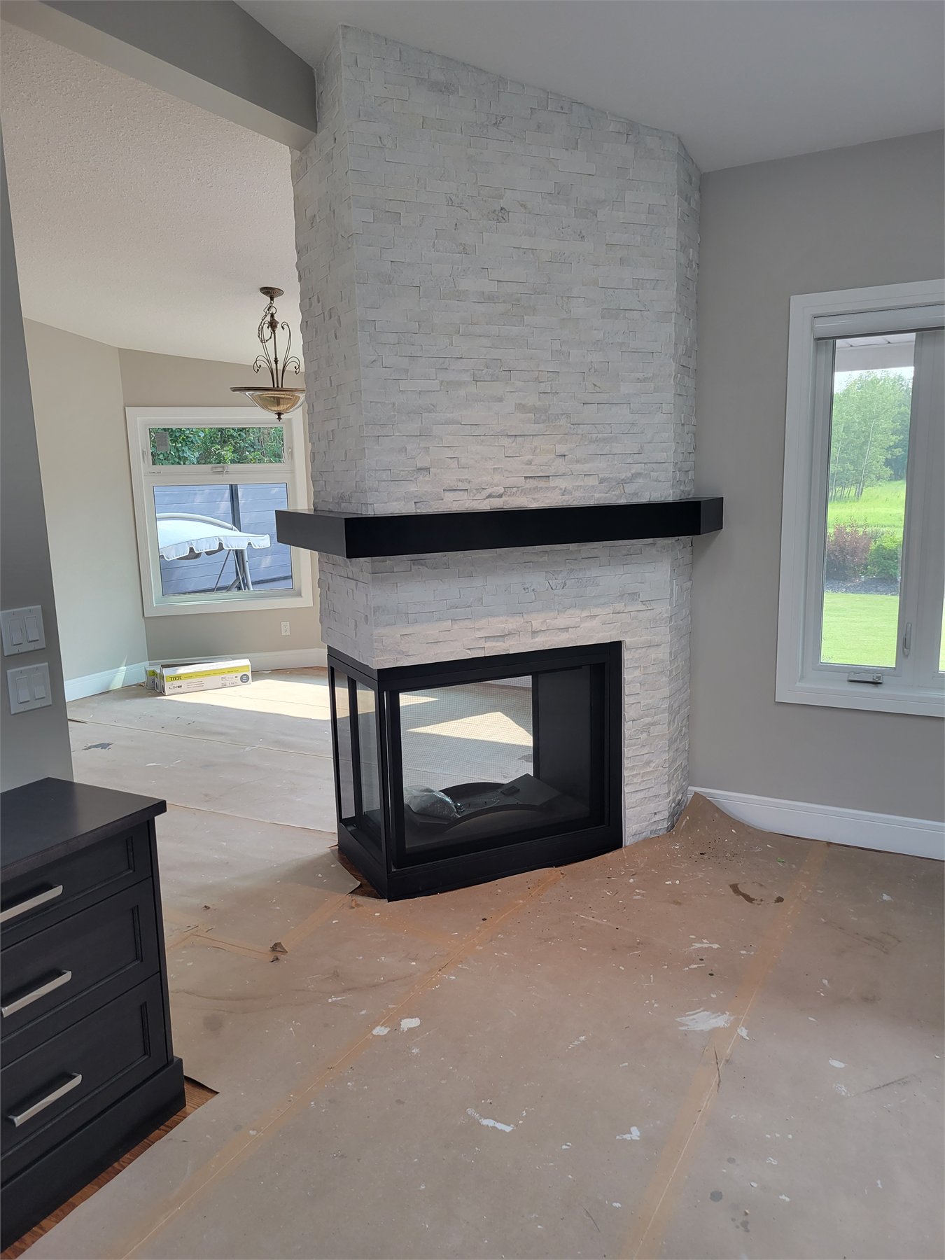 Travertine ledge stone fireplace with mitered corners and an angled ceiling