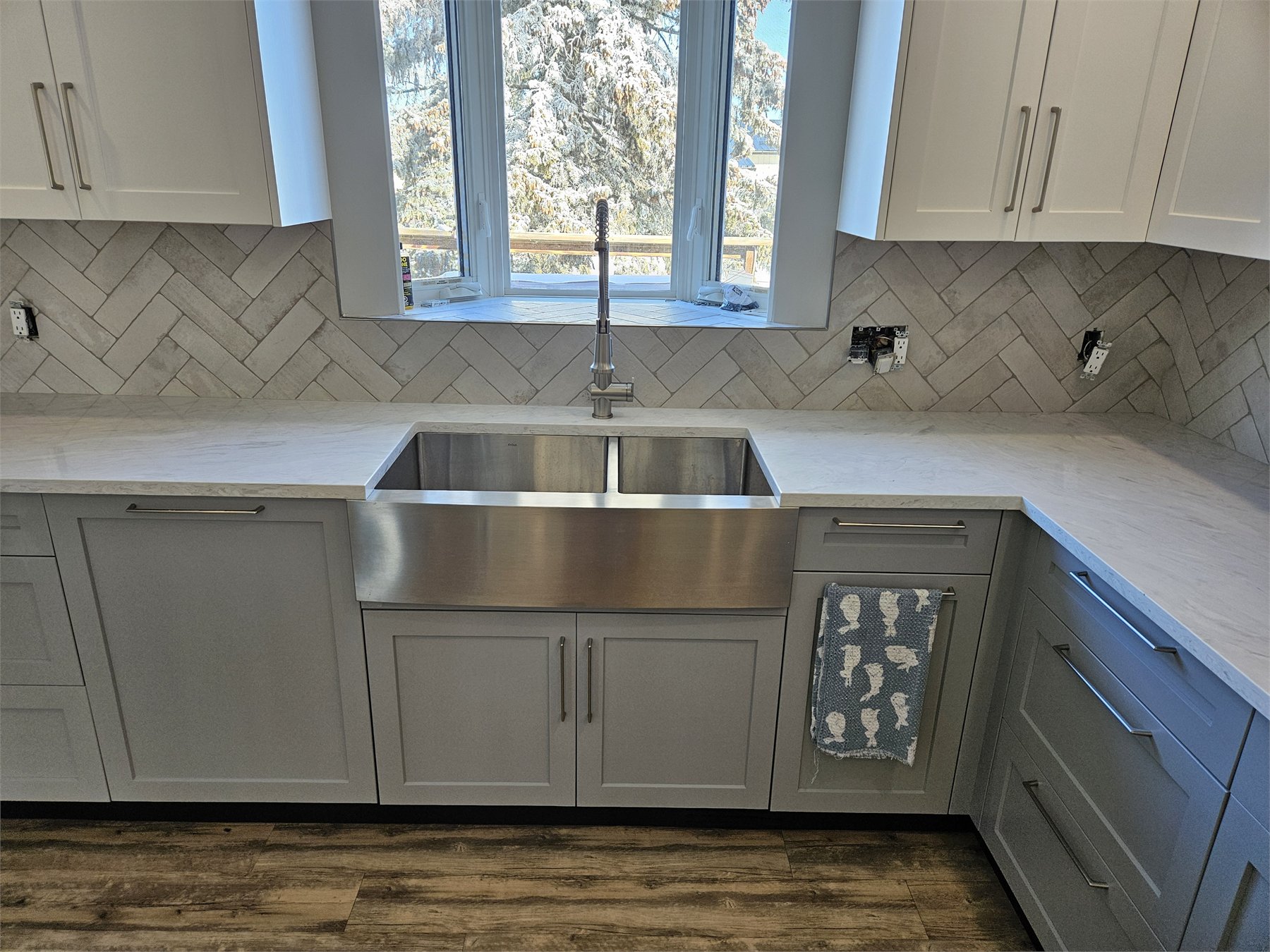Herringbone kitchen backsplash with continuous grout lines around wrapped corners