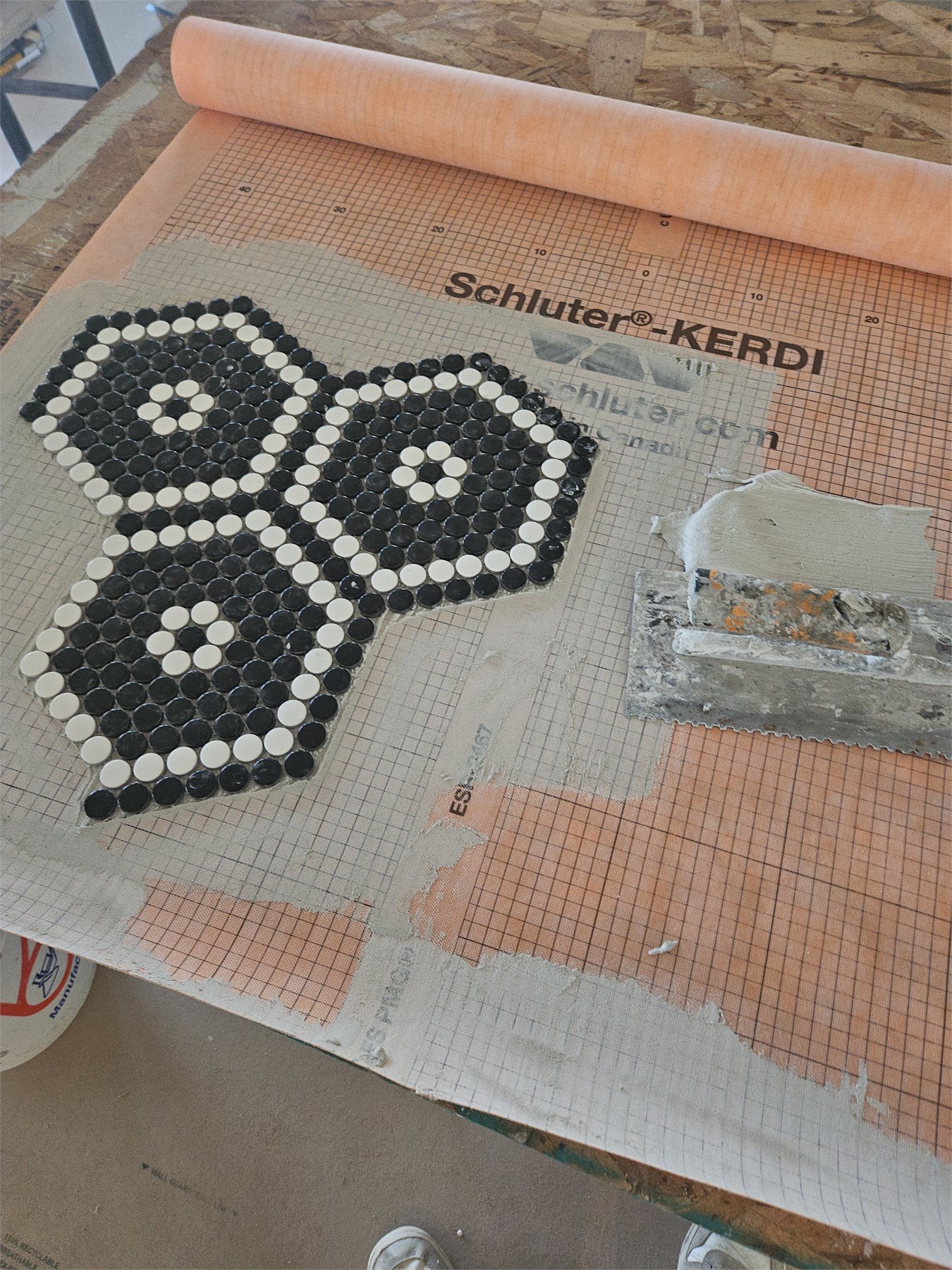 Custom black and white penny tile floor assembled in a hand-built pattern, detail view 2